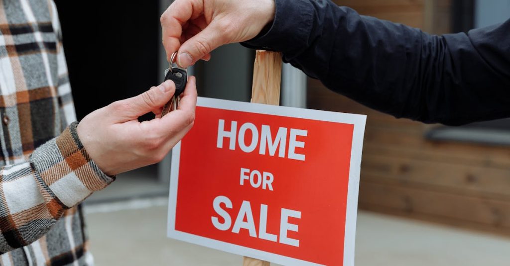 Close-up of a home for sale sign with people exchanging keys.